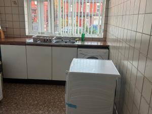 a small kitchen with a sink and a washing machine at Komegloba Exquisite room in Manchester