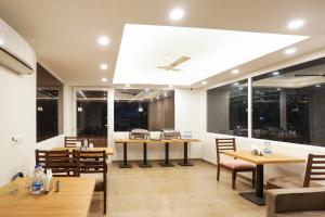 a restaurant with tables and chairs and windows at Super Townhouse MA-32 in Gurgaon