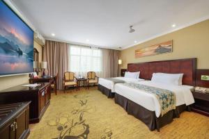 a hotel room with two beds and a television at Sun Island Holiday Hotel in Shenzhen +257 photos