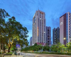 a city skyline with tall buildings and a street at Sun Island Holiday Hotel in Shenzhen