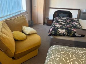 a room with a yellow couch and a bed at Komegloba Exquisite room in Manchester
