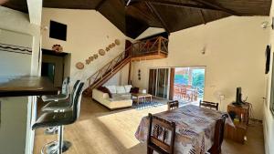 a living room with a table and a room with a staircase at VILLA RAVOLA - Ambondrona in Nosy Be