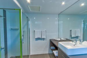 um banheiro com pia e box de vidro em Mackay Oceanside Central Hotel Official em Mackay mais 31 fotografias