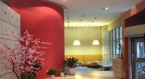 an office lobby with a red wall and flowers at Jinjiang Inn Hangzhou Xihu Avenue Branch in Hangzhou