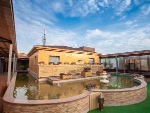 a house with a pond in the yard at GreenTree Inn Nanjing Software Valley DaDingFang Express Hotel in Nanjing