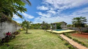 a yard with a swimming pool and a house at VILLA RAVOLA - Ambondrona in Nosy Be