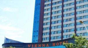 un edificio alto con un cartello davanti di Vienna Hotel Qingdao Jiaozhou Branch a Jiaoxian