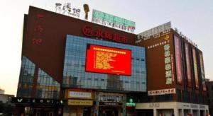 ein großes Gebäude mit einem roten Schild drauf in der Unterkunft GreenTree Inn Hefei Huangshan Road Daxidi 1912 Express Hotel in Hefei