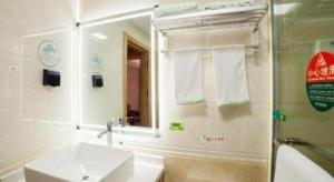un bagno con lavandino e specchio di GreenTree Inn Hefei Chenghuangmiao San Xiao Kou Subway Station Hotel a Hefei Altre 160 foto
