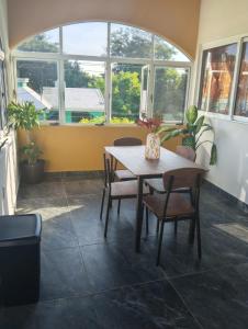 a table and chairs in a room with windows at Shalom in Ciudad Valles