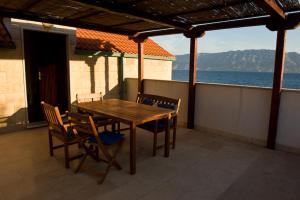 a wooden table and chairs on a balcony with the ocean at Villa Sofia in Povlja