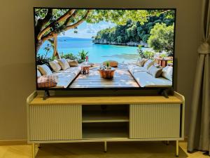 uno schermo televisivo con vista su un tavolo in cima a una stanza di Апартаменты у океана пляж Бангтао Title Legendary Bangtao a Bang Tao Beach