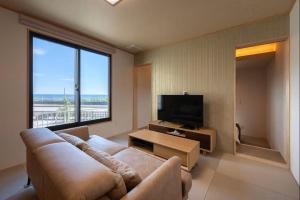 a living room with a couch and a flat screen tv at 割烹旅館 清都 in Hongō