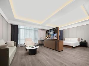 Una sala de estar con un sofá y un televisor. en Royalton Hotel Xi'an Qujiang Conference Center Mixc, en Xi'an