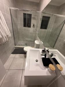 Luxury Coastal Escape in Strand في Somerset West: حمام أبيض مع حوض ومرحاض