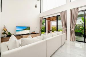 a living room with white couches and a flat screen tv at 3BR Pool Villa JAAI in Ban Saiyuan (1)