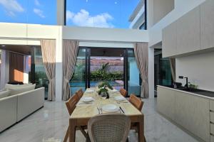 a dining room with a table in a house at 3BR Pool Villa JAAI in Ban Saiyuan (1)