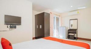a bedroom with a bed and a tv on the wall at Supattranai Home Hua Hin in Ban Bo Khaem