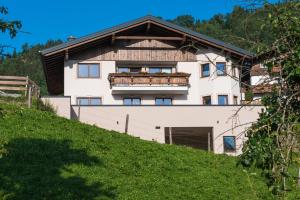 ein weißes Gebäude mit einem Balkon auf einem Hügel in der Unterkunft Sedlhof Apartment in Grub