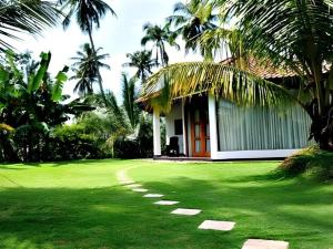 a house with a green yard with a grass field at Brook Boutique in Madahapola