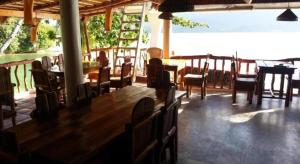 un ristorante con tavoli e sedie in legno in una stanza di Dolphinbay Beachfront & Dive Resort a Sabang