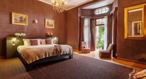 a bedroom with a large bed and a chandelier at Craigbank Nuwaraeliya in Nuwara Eliya