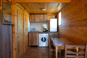 Sunrise Gelati في Motsameta: مطبخ مع غسالة وطاولة خشبية +13 صورة