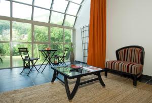 a living room with a glass table and a couch at Tempologis - Chateau de la Rochette in Fontaine