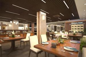 un ristorante con tavoli in legno e sedie bianche di Marissa Hotel & Spa Hai Tien a Trung Ngoai