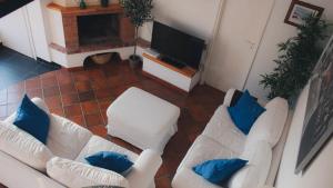 een woonkamer met twee witte banken en een televisie bij La Villetta di Cefalù in Cefalù