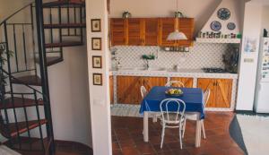 a small kitchen with a blue table and chairs at La Villetta di Cefalù in Cefalù