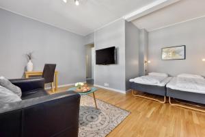 uma sala de estar com um sofá e uma cama em Forenom Serviced Apartments Oslo Rosenborg em Oslo