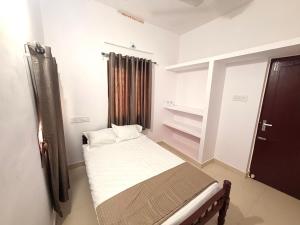 a small bedroom with a bed and a window at AETERNA Homestay in Fort Kochi