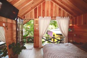 ein Schlafzimmer mit einem Bett und einem großen Fenster in der Unterkunft September Garden Homestay in Da Lat + 103 Fotos