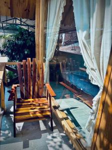 eine Holzbank auf einer Veranda neben einem Pool in der Unterkunft September Garden Homestay in Da Lat