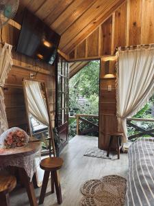 Zimmer mit einem Bett, einem Tisch und einem TV in der Unterkunft September Garden Homestay in Da Lat