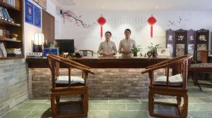 two men standing at a counter in a restaurant at Oriental Hotel in Dongguan
