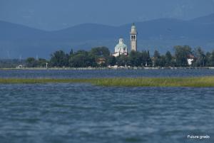 a large body of water with a building in the background at Capitol Apartments in Grado