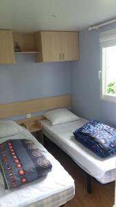 レ・マトゥにあるMobil Home - Domaine du Galantのベッド2台と窓が備わる小さな客室です。
