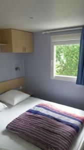 a bedroom with a bed with a window at Mobil Home - Domaine du Galant in Les Mathes