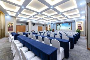 uma sala de conferências com mesas azuis e cadeiras brancas em James Joyce Coffetel Changsha Wanjiali Baoqiaobei Metro Station em Changsha