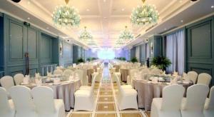 a banquet hall with white tables and chairs and chandeliers at Great International Hotel in Heyuan +221 photos