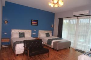 a blue room with two beds and a chair at 500Km Home in Hualien City