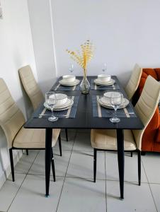 een zwarte eettafel met stoelen en een vaas met bloemen bij Buxton Point Luxury Haven in Mombasa