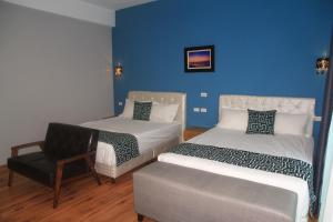 a room with two beds and a chair in it at 500Km Home in Hualien City
