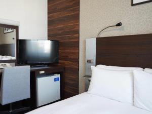 um quarto de hotel com uma cama e uma televisão em Comfort Hotel Tokyo Higashi Nihombashi em Tóquio