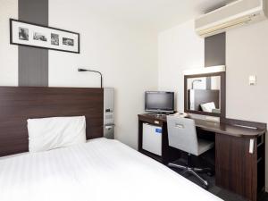 a hotel room with a bed and a desk with a computer at Comfort Hotel Shin Yamaguchi in Yamaguchi +24 photos