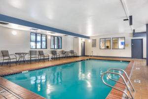 a pool with chairs and tables in a building at Comfort Inn Federal Way - Seattle in Federal Way