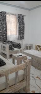 un salon avec des canapés, des tables et des fenêtres dans l'établissement Zlaal Lounge, à Watamu