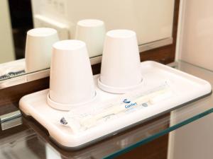 a bathroom counter with a tray with white cups on it at Comfort Inn Omihachiman in Omihachiman